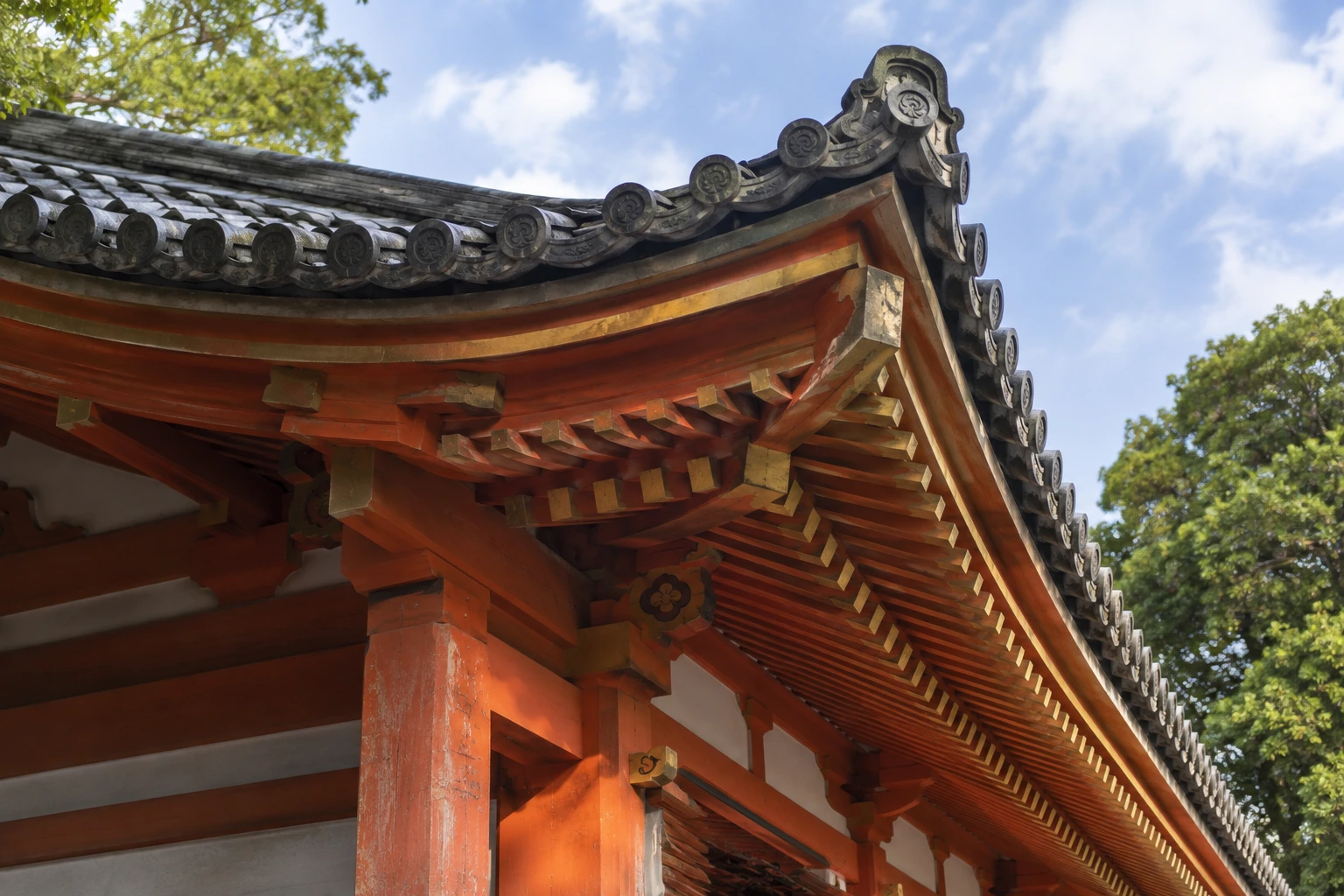 八坂神社の西楼門を斜め下から見た瓦屋根の曲線と朱色の柱