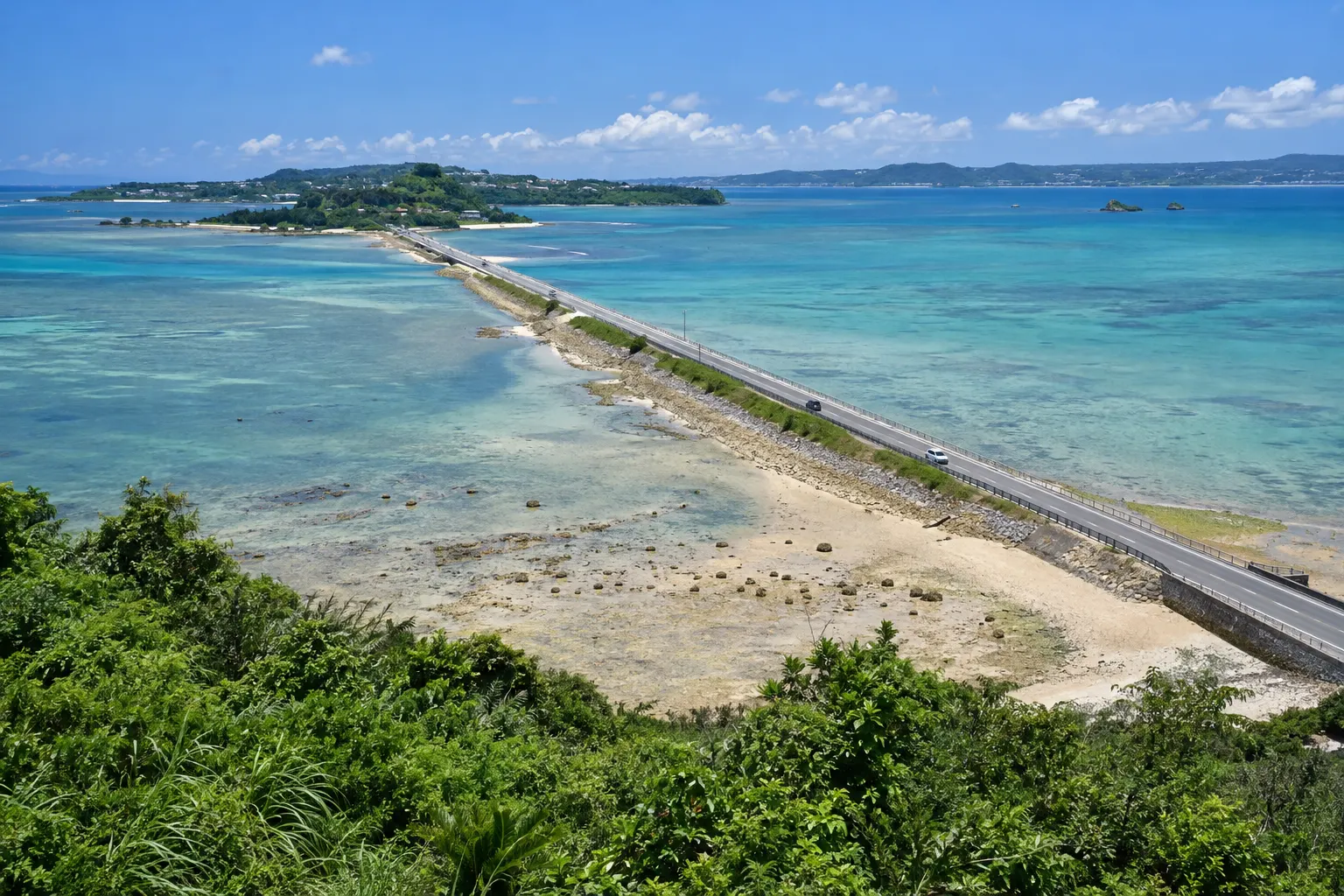 うるま市の海中道路が浅い海の上を平安座島へ向かって延びる様子